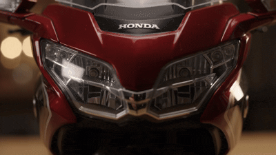 Close-up of the glowing headlight on a diecast Gold Wing style motorcycle model
